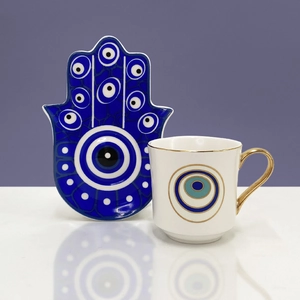 Dettaglio vassoio Hamsa in ceramica e tazzina con occhio di Allah e manico oro