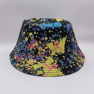 Detail of a reversible bucket hat with vibrant paint splatter pattern on a black base