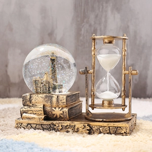 Detailed close-up of retro Eiffel Tower crystal ball with rotating hourglass on book base