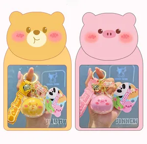 Detail of cute acrylic keychains with yellow bear and pink pig charms in clear spheres