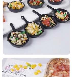 Macro detail of miniature fried rice and noodles in a black pan and bamboo basket