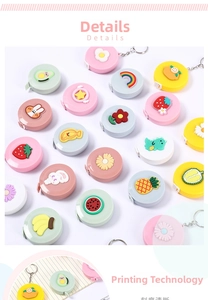Close-up of cute cartoon retractable measuring tapes with colorful charms and keychains