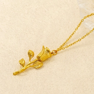 Gros plan détaillé d'un collier pendentif rose dorée avec textures fines de pétales