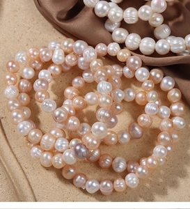 Macro shot of colorful natural freshwater pearls on silk fabric showing fine texture