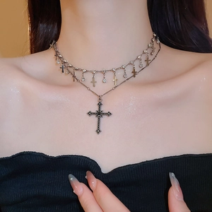 Close-up of double-layered cross necklace with black rhinestone pendant on a model