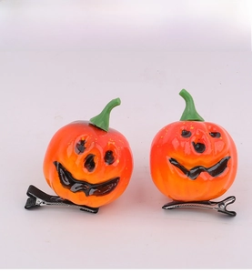 Detail shot of orange Halloween pumpkin hair clips with funny faces and black metal duckbill clips