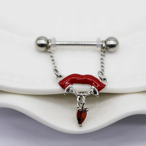 Macro shot of red lips nipple ring with a hanging red teardrop gem on a ceramic plate