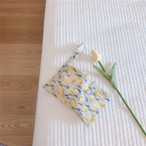 Detail view of quilted cotton mini tote with yellow tulip pattern and soft texture