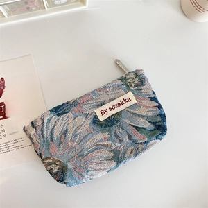 Close-up of jacquard woven pouch featuring vintage blue and white sunflower patterns
