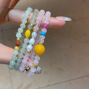 Détail de bracelets en perles de jade Hetian, ambre et perles sur le poignet d'une femme