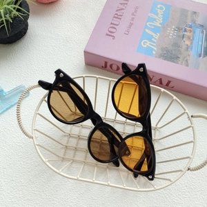 Close-up of black cat-eye sunglasses with heart-shaped stud and size detail 54-18-136