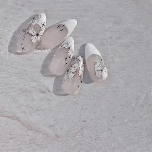 Détail de stickers à ongles fins avec papillons blancs et étoiles dans un style japonais