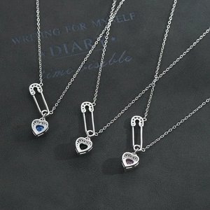 Three gold-plated heart safety pin necklaces with blue, black, and purple zircon stones