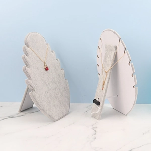 Grey velvet necklace display stand with leaf-shaped design for jewelry organization