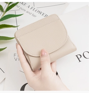 Detailed close-up of beige lychee grain leather wallet with precision stitching finish