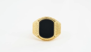 Macro shot of men's gold titanium ring with black obsidian inlay and snake skin texture