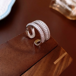 Detailansicht silberner Doppelring mit Zirkonia auf dunklem Walnussholz Hintergrund