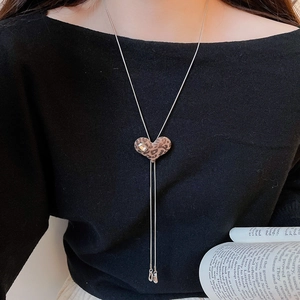 Detail of leopard print heart pendant on silver snake chain with rhinestone accent