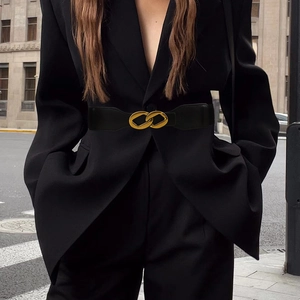Fashion close-up of a wide elastic black corset belt with iconic gold interlocking buckles