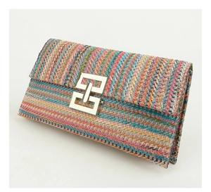 Macro shot of colorful bohemian woven straw fibers and a golden geometric buckle detail