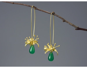 Detail of elegant gold flower earrings featuring green chalcedony teardrop pendants
