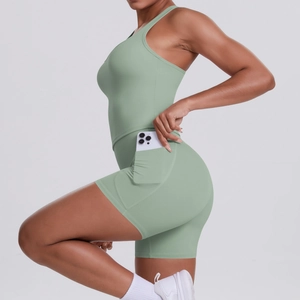 Detail of mint green yoga set featuring a side pocket holding a smartphone on shorts