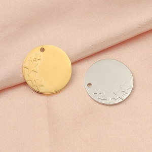 Close-up of gold and silver stainless steel star embossed circular pendant charms