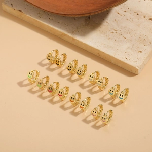 Close-up of colorful smiley face earrings in various vibrant colors on stone display
