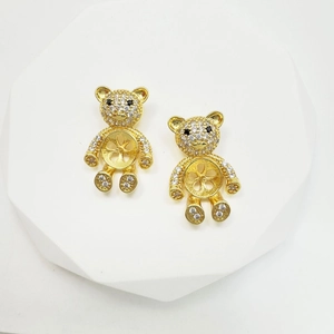 Macro shot of gold-plated bear-shaped jewelry settings with cubic zirconia and pearl cup