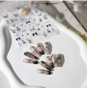 Nahaufnahme von Nagelstickern mit Schmetterlings- und Sternmuster und Metalleffekt