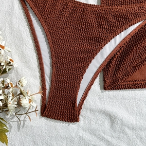 Detail of brown crinkle fabric bikini bottoms with high elasticity and white lining