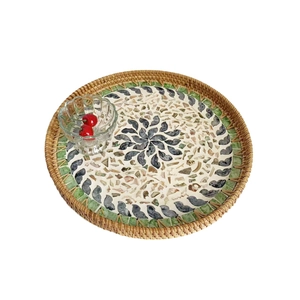Round rattan serving tray with inlaid mosaic pattern and decorative glass bowl decor