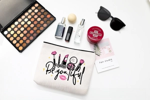 Close-up of canvas makeup bag with lipstick prints and Always Be You-tiful text