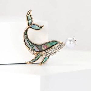 Broche baleine dorée élégante avec nacre irisée, strass brillants et perle blanche