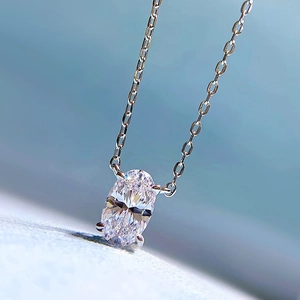 Macro shot of oval-cut sparkling diamond pendant with four-prong silver setting