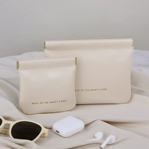 Beige leather pouch with gold squeeze closure for lipstick, cables, and glasses
