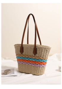 Detail of bohemian straw bag with rainbow stripes and brown PU leather straps