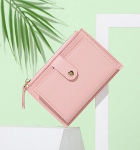 Detailed view of pink PU leather multi-slot wallet with snap closure on a stone prop
