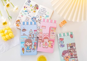 Flat lay of colorful cute cartoon planners in blue, pink, and green with magnetic closures