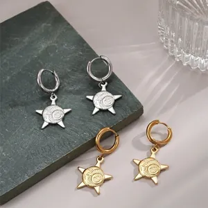Retro stainless steel sun pendant earrings in silver and gold displayed on stone