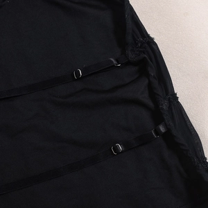 Detailed macro view of adjustable straps and sheer pleated mesh fabric on the black top