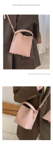 Pink minimalist bucket bag with long strap and metal bottom studs shown in detail