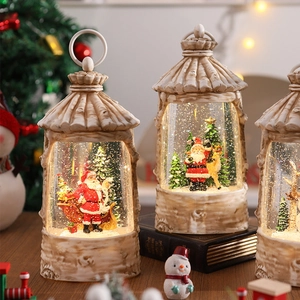 Close-up of a festive glowing Christmas snow globe featuring Santa Claus and a reindeer