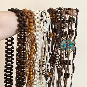 Detail of handcrafted bohemian waist chain with wooden beads and woven rope texture