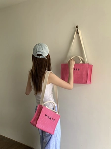 Pink straw woven tote bag in two sizes with Paris text detail on shoulder straps