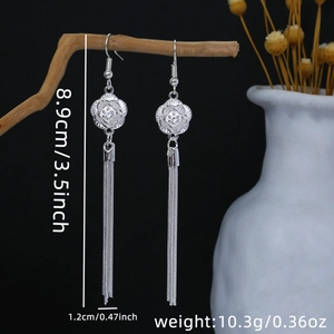 Detail of silver bohemian tassel earrings hanging on branch with size and weight info