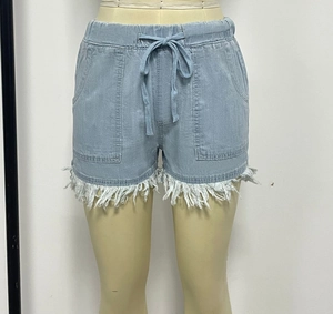 Détail du short en jean avec taille élastique à cordon et ourlet à franges blanches