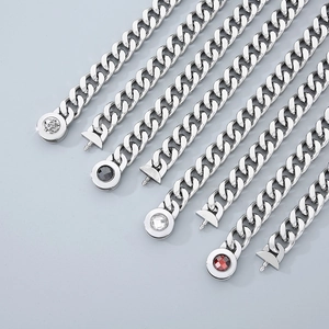 Detail view of 13mm silver Cuban links featuring skull motifs and inlaid gemstone accents