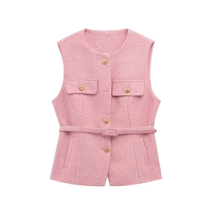 Detail of pink sequin tweed vest featuring golden embossed buttons and matching belt