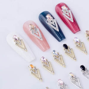 V-shaped metal nail art charms with teardrop rhinestones on various nail colors